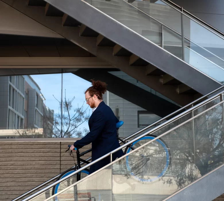 man-carrying-bicycle-down-stairs-full-shot